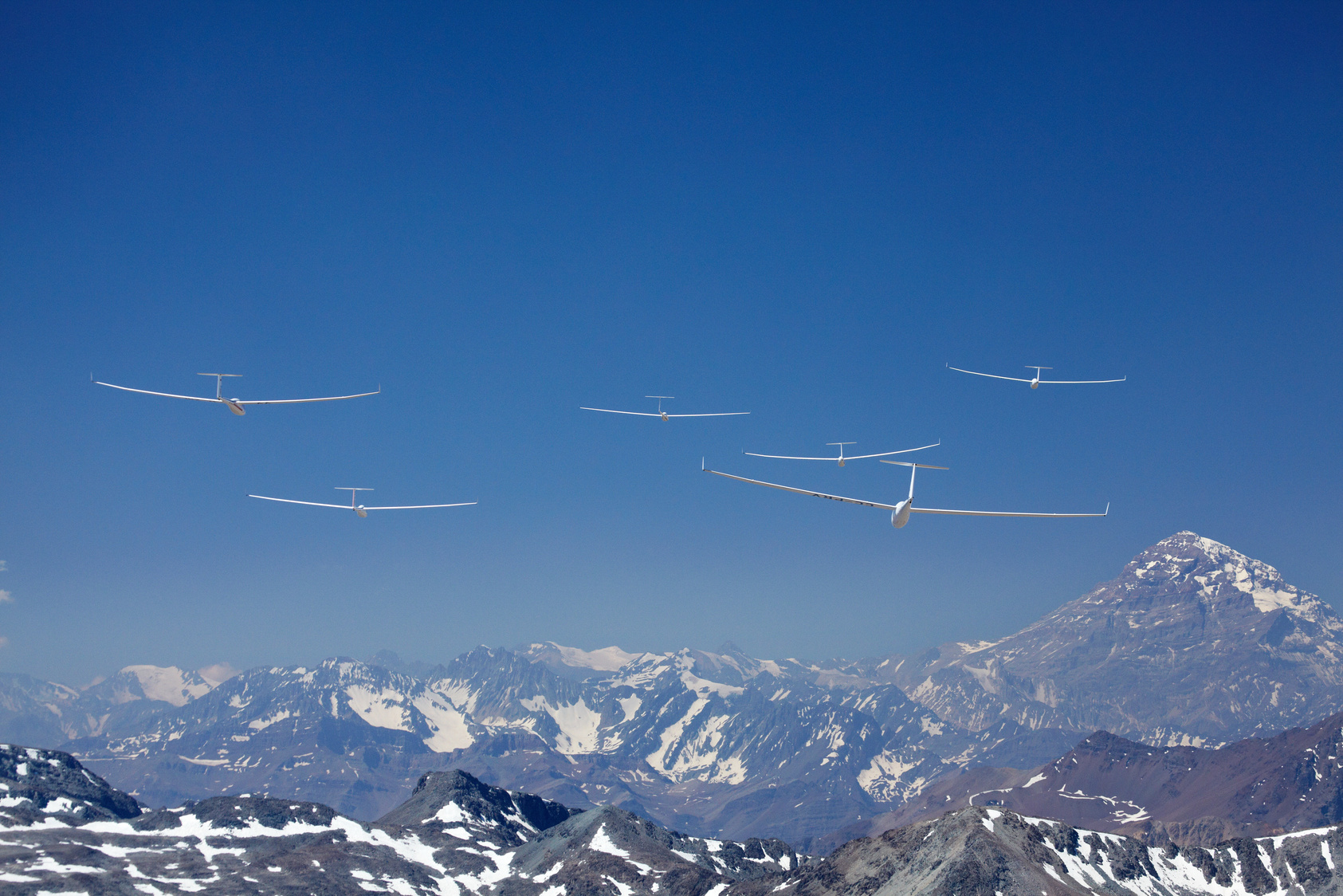 Segelflugzeuge im Formationsflug vor den Anden